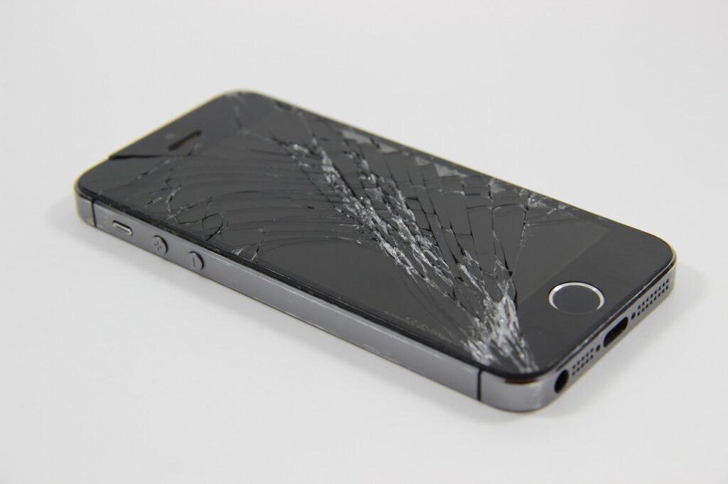 Pantalla del móvil rota con grietas en el cristal sobre fondo oscuro