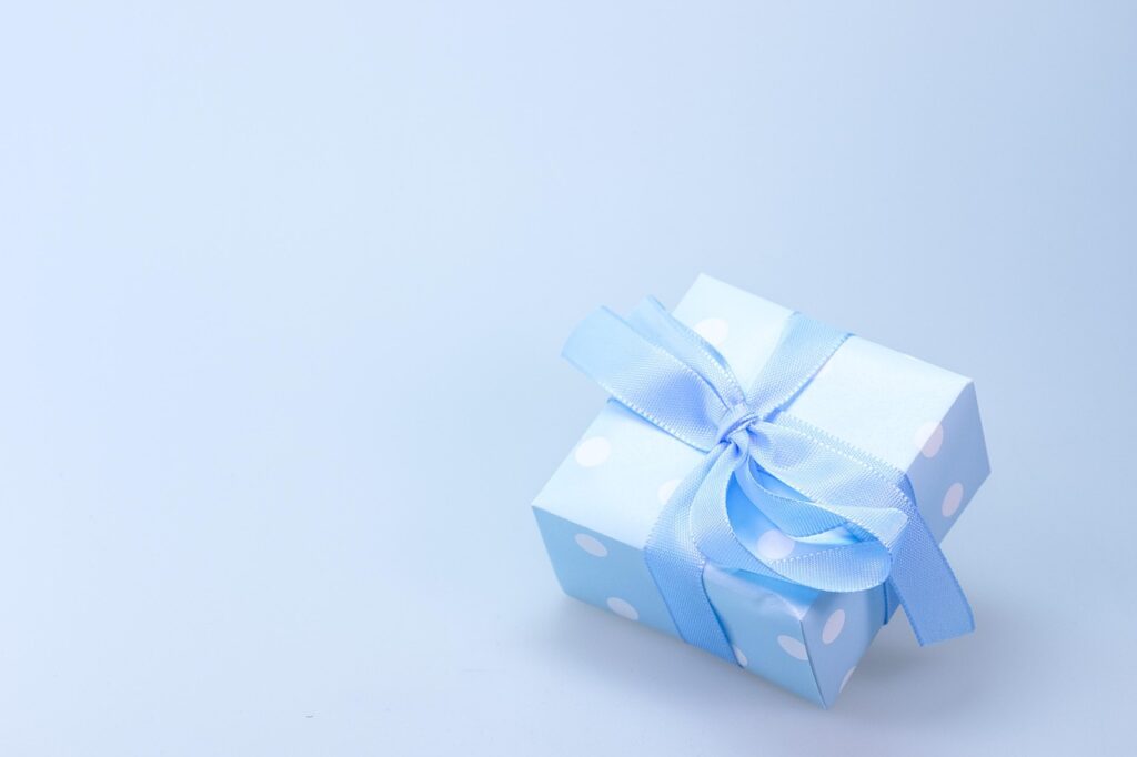 Caja de regalo abierta con un smartphone en el interior, decorada con motivos navideños
